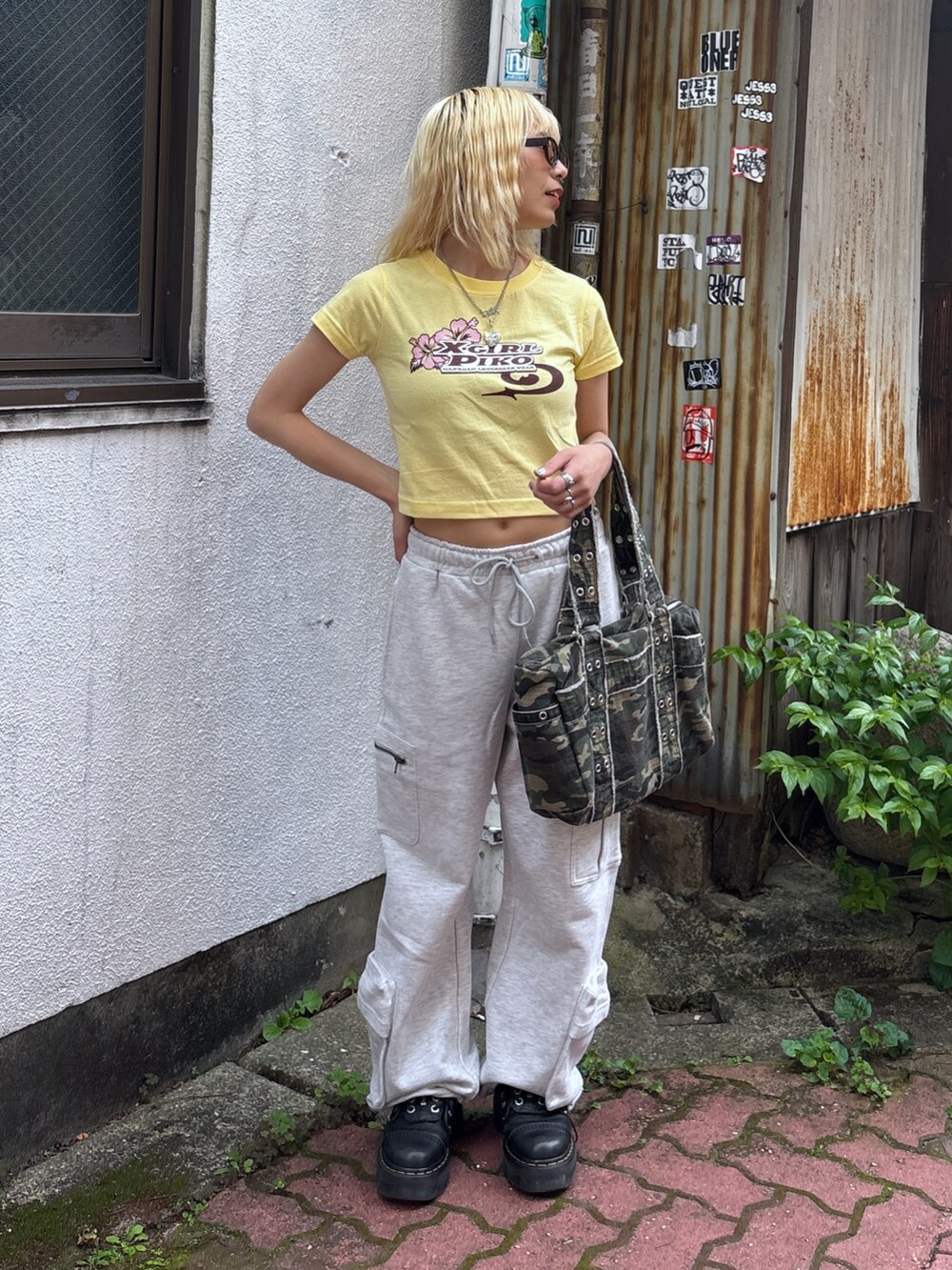 イエロー系のTシャツ/カットソー、グレー系のスウェットパンツ、その他のハンドバッグを着用したレディースの夏コーディネートの2枚目の写真
