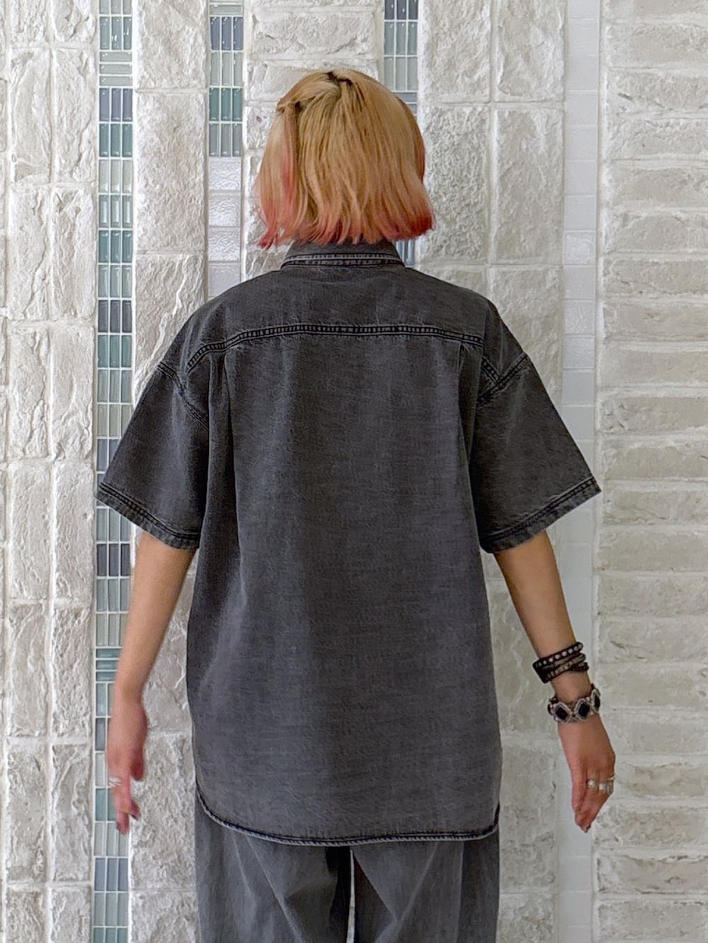 ブラック系のデニムパンツ、グレー系のショルダーバッグ、ブラック系のシャツ/ブラウスを着用したレディースの夏コーディネートの5枚目の写真