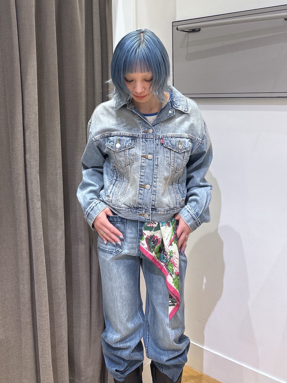 ブルー系のデニムジャケット、ブラック系のブーツ、ブルー系のデニムパンツを着用したレディースの春コーディネートの4枚目の写真