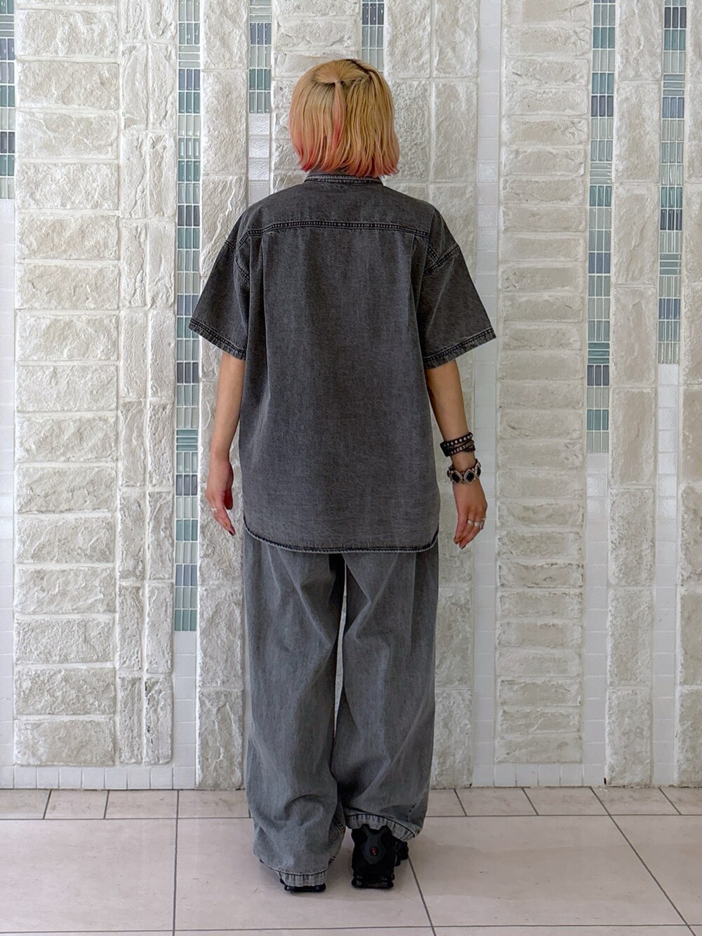 ブラック系のデニムパンツ、グレー系のショルダーバッグ、ブラック系のシャツ/ブラウスを着用したレディースの夏コーディネートの4枚目の写真