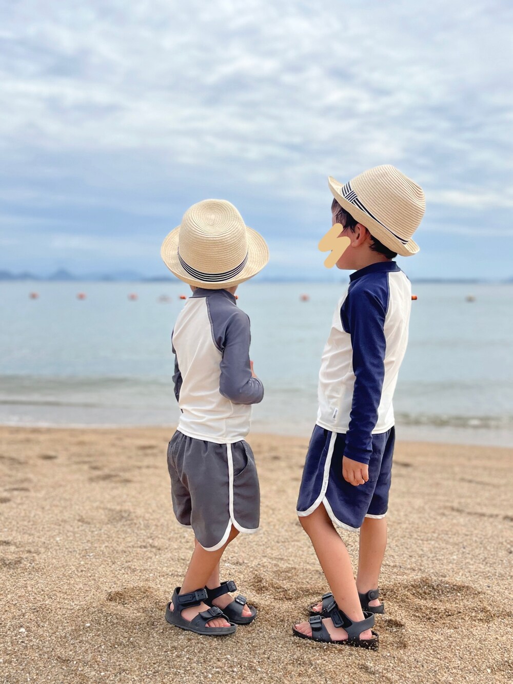 ブラック系のサンダル、ブルー系のラッシュガード、グレー系のラッシュガードを着用したキッズの夏コーディネートの2枚目の写真