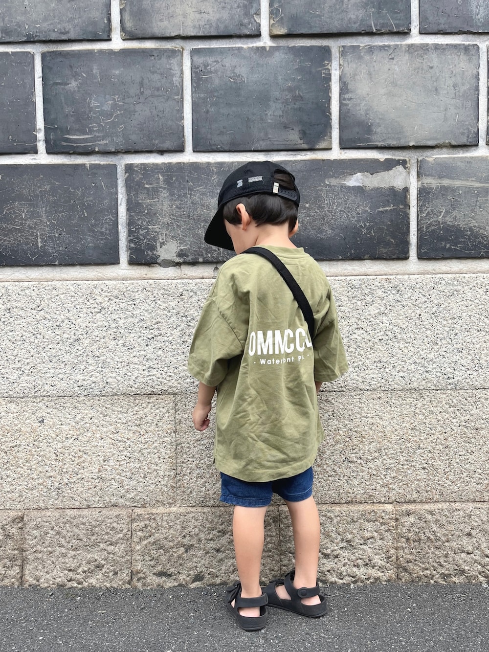 グリーン系のTシャツ/カットソー、ブラック系のショルダーバッグ、ブルー系のパンツを着用したキッズの夏コーディネートの2枚目の写真