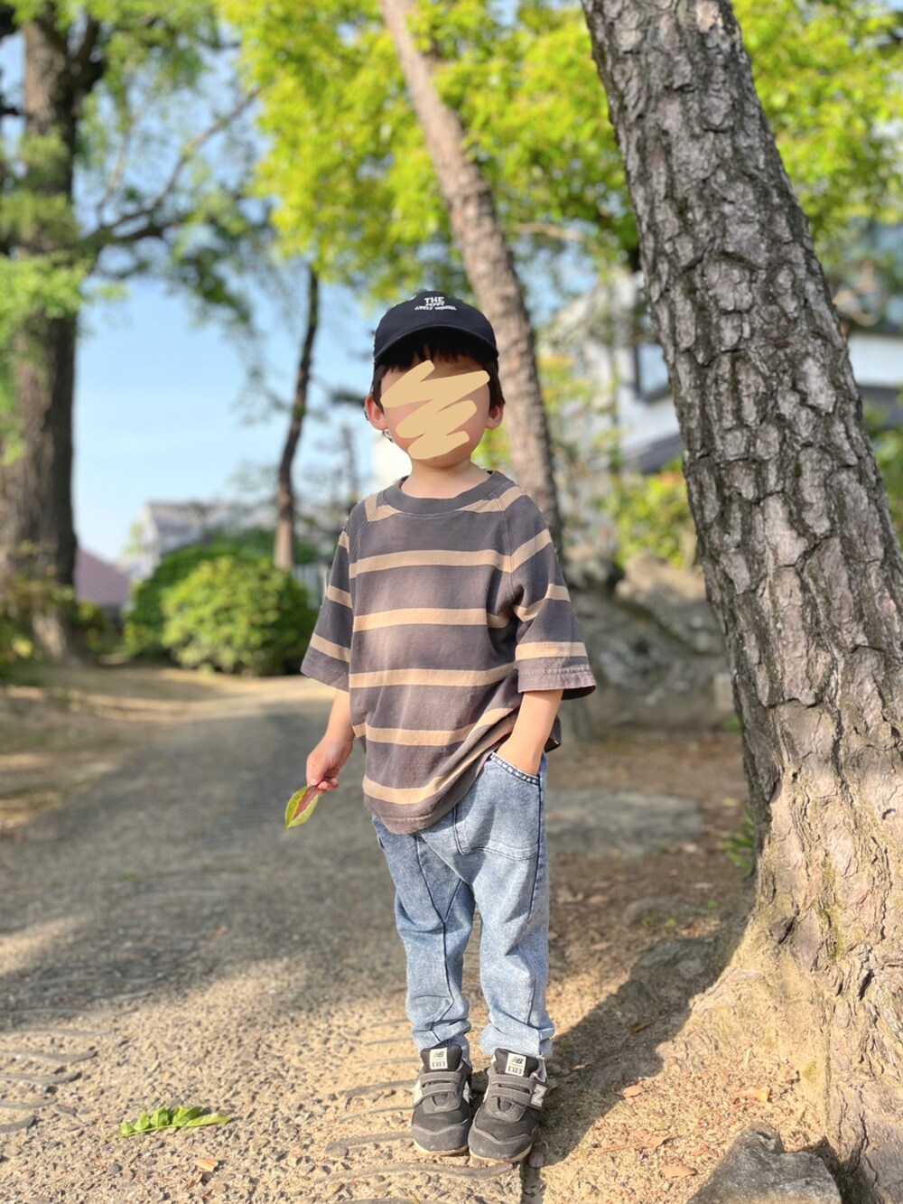 ブラウン系のTシャツ/カットソー、ブルー系のデニムパンツ、ブラック系のスニーカーを着用したキッズの春コーディネートの2枚目の写真