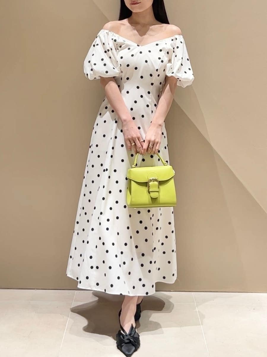 ブラック系のパンプス、その他のワンピース、グリーン系のハンドバッグを着用したレディースの春コーディネートの4枚目の写真