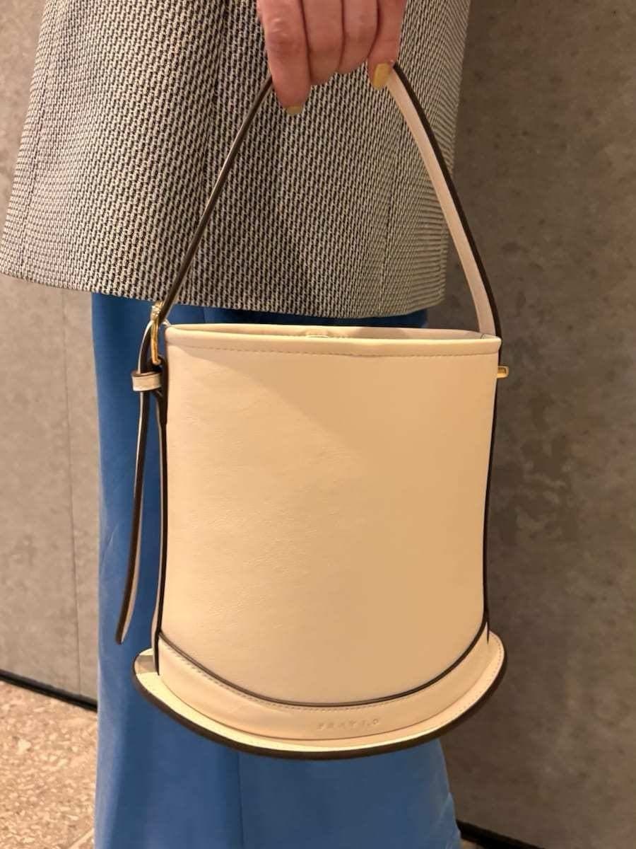 ホワイト系のハンドバッグ、ブラック系のサンダルを着用したレディースの春コーディネートの8枚目の写真