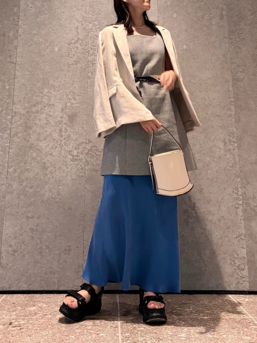 ホワイト系のハンドバッグ、ブラック系のサンダルを着用したレディースの春コーディネートの3枚目の写真