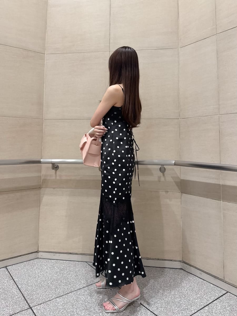 ブラック系のワンピース、ホワイト系のカーディガン/ボレロ、シルバー系のサンダルを着用したレディースの春コーディネートの7枚目の写真