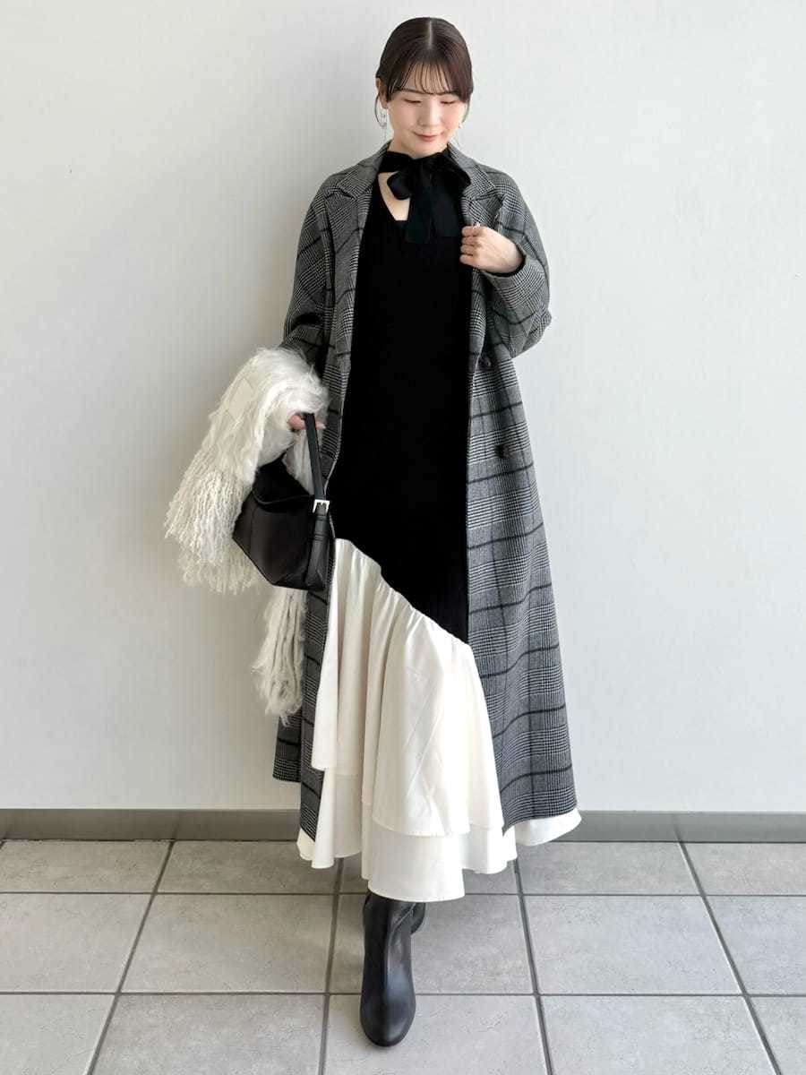 ブラック系のブーツ、その他のチェスターコート、ブラック系のハンドバッグを着用したレディースの秋コーディネートの2枚目の写真