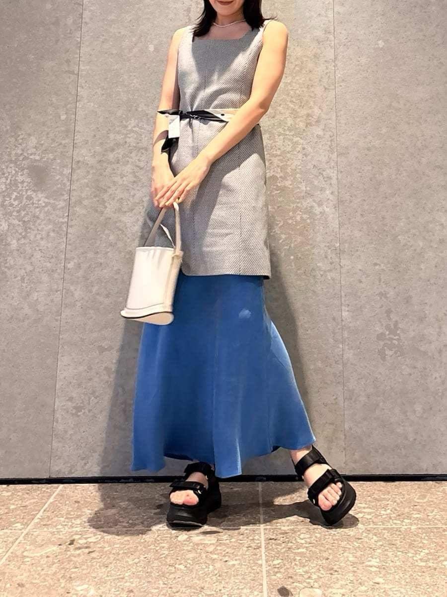 ホワイト系のハンドバッグ、ブラック系のサンダルを着用したレディースの春コーディネートの5枚目の写真