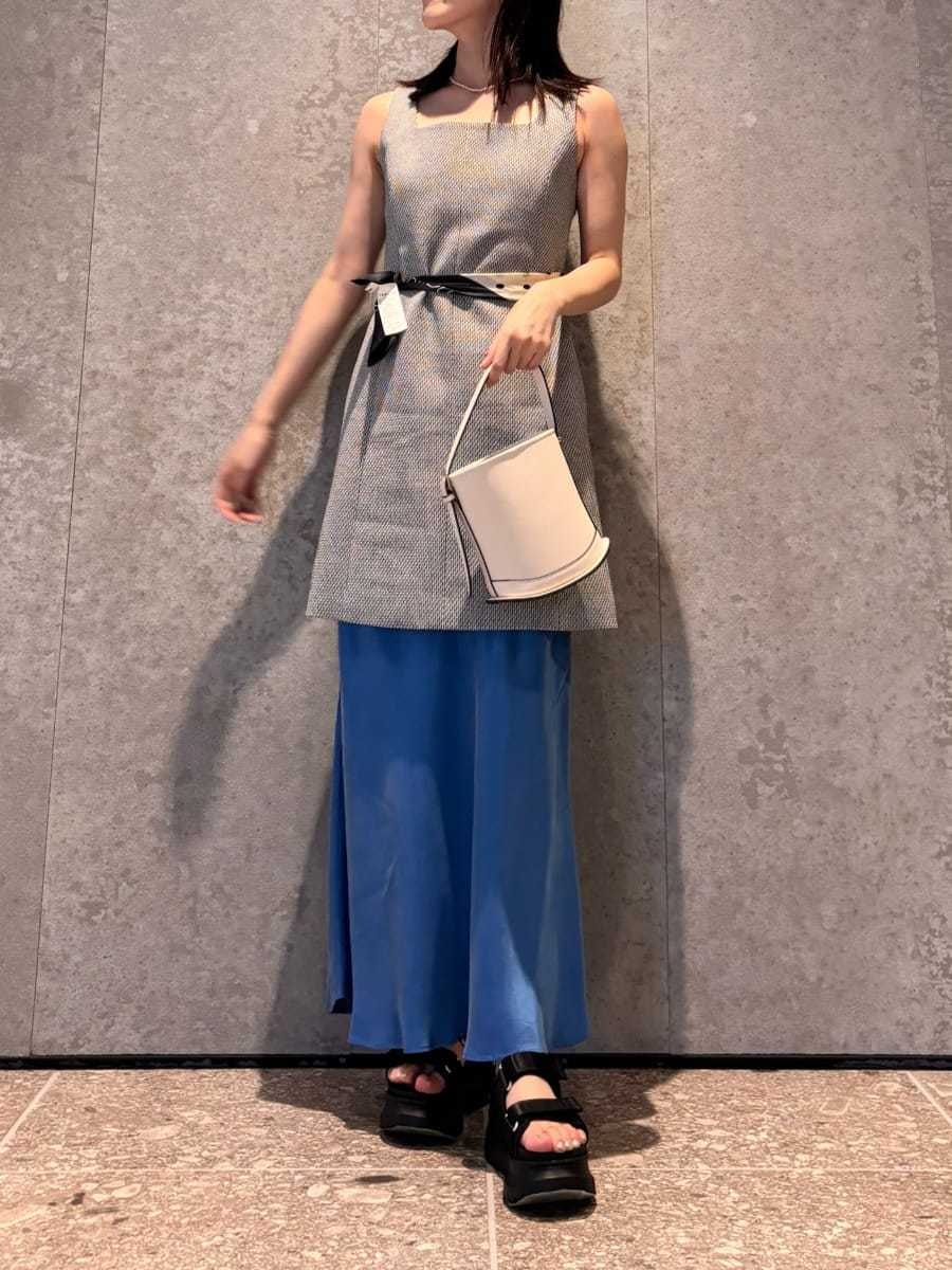 ホワイト系のハンドバッグ、ブラック系のサンダルを着用したレディースの春コーディネートの4枚目の写真