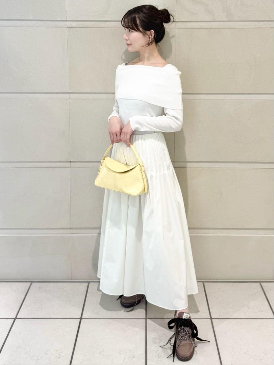 イエロー系のハンドバッグを着用したレディースの冬コーディネートの3枚目の写真