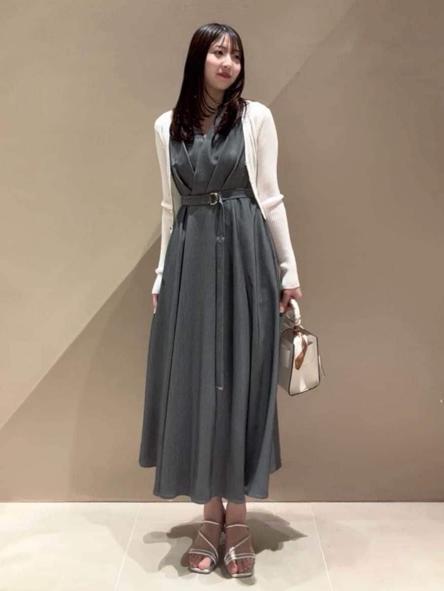 グレー系のワンピース、ホワイト系のカーディガン/ボレロ、シルバー系のサンダルを着用したレディースの春コーディネートの2枚目の写真