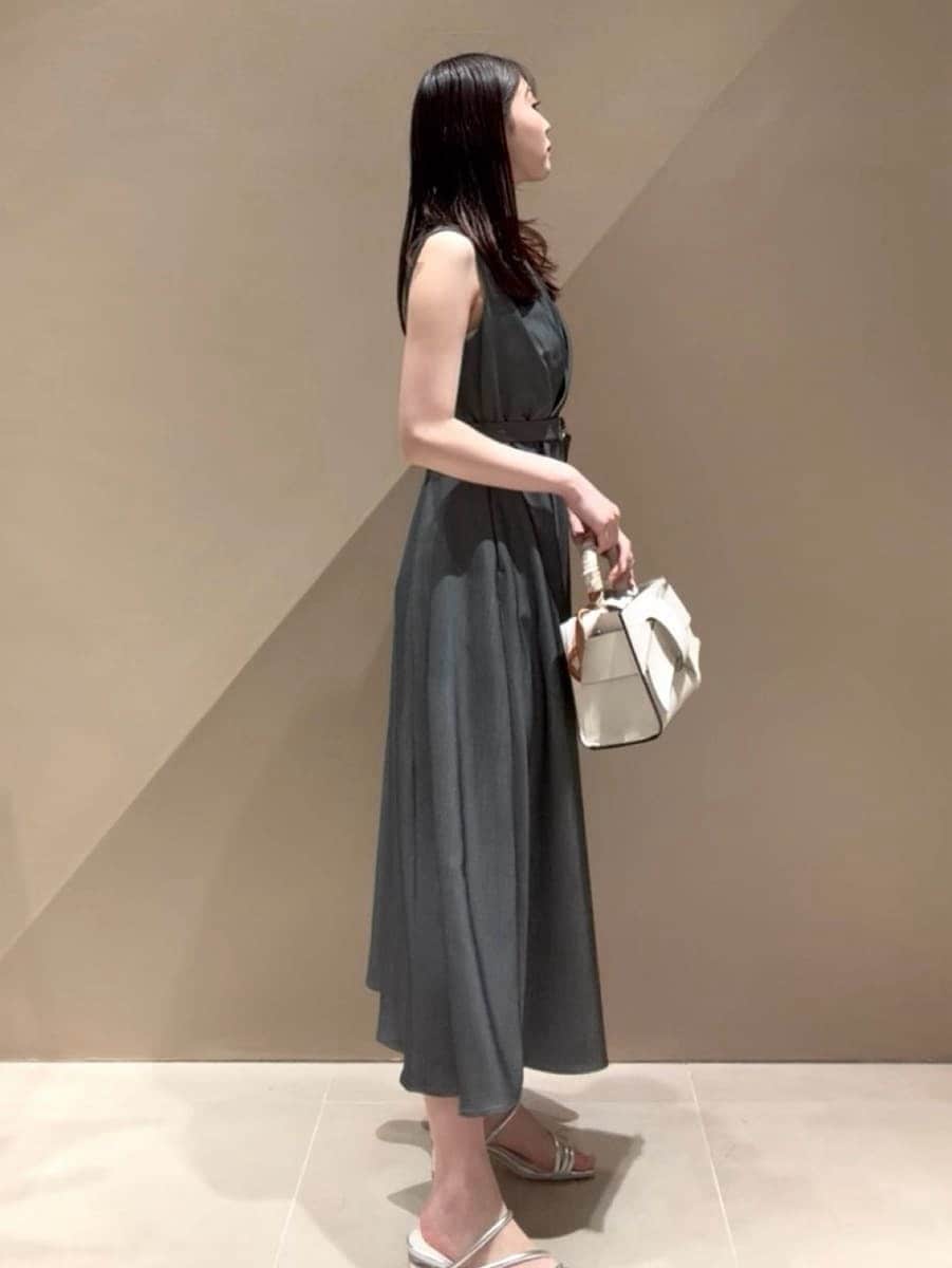 グレー系のワンピース、ホワイト系のカーディガン/ボレロ、シルバー系のサンダルを着用したレディースの春コーディネートの4枚目の写真