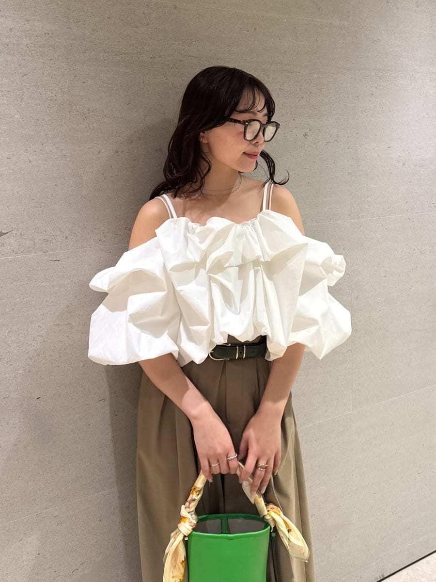 グリーン系のハンドバッグ、ホワイト系のサンダル、ホワイト系のシャツ/ブラウスを着用したレディースの冬コーディネートの6枚目の写真