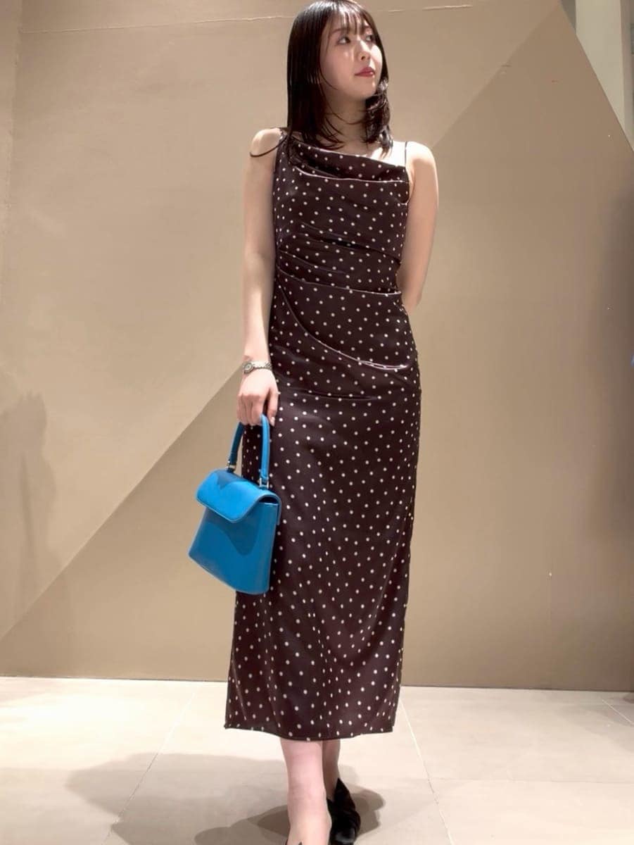 ブラック系のパンプス、ベージュ系のトレンチコート、ブラウン系のワンピースを着用したレディースの冬コーディネートの4枚目の写真