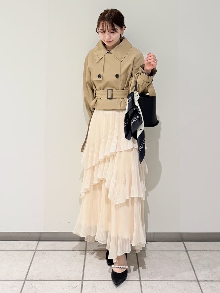 ベージュ系のスカート、ベージュ系のトレンチコート、ブラック系のニット/セーターを着用したレディースの冬コーディネートの2枚目の写真