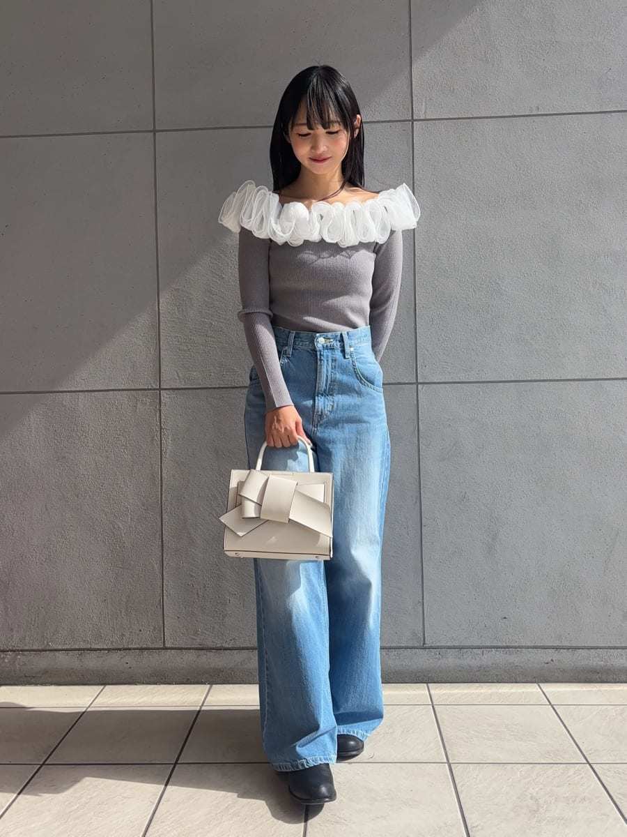 ブルー系のデニムパンツ、ベージュ系のトレンチコート、グレー系のニット/セーターを着用したレディースの冬コーディネートの2枚目の写真