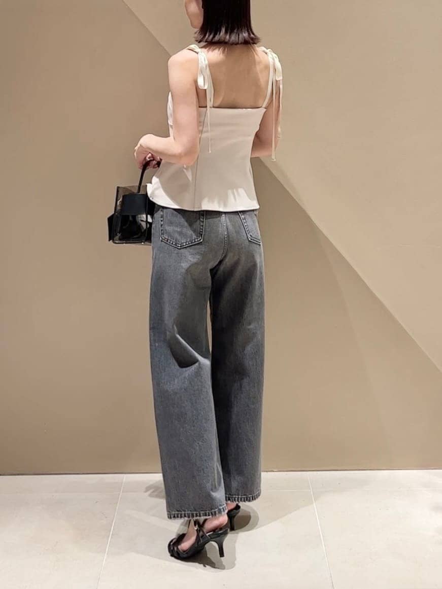 ブラック系のハンドバッグ、ブラック系のデニムパンツ、ベージュ系のその他トップスを着用したレディースの夏コーディネートの4枚目の写真