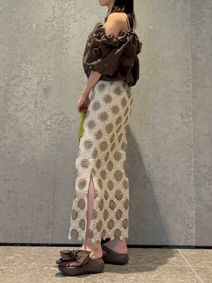 グリーン系のハンドバッグ、ブラウン系のシャツ/ブラウス、ブラウン系のサンダルを着用したレディースの春コーディネートの2枚目の写真