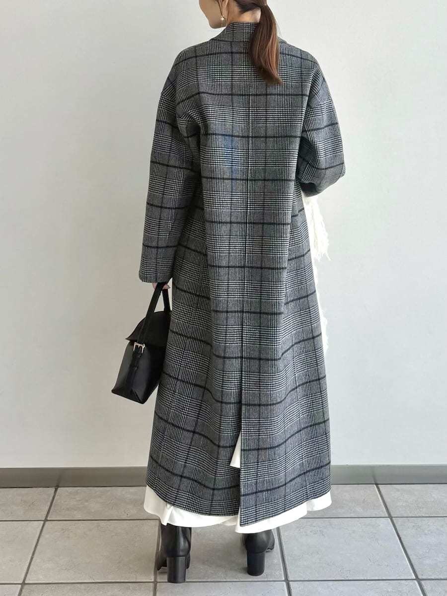 ブラック系のブーツ、その他のチェスターコート、ブラック系のハンドバッグを着用したレディースの秋コーディネートの9枚目の写真