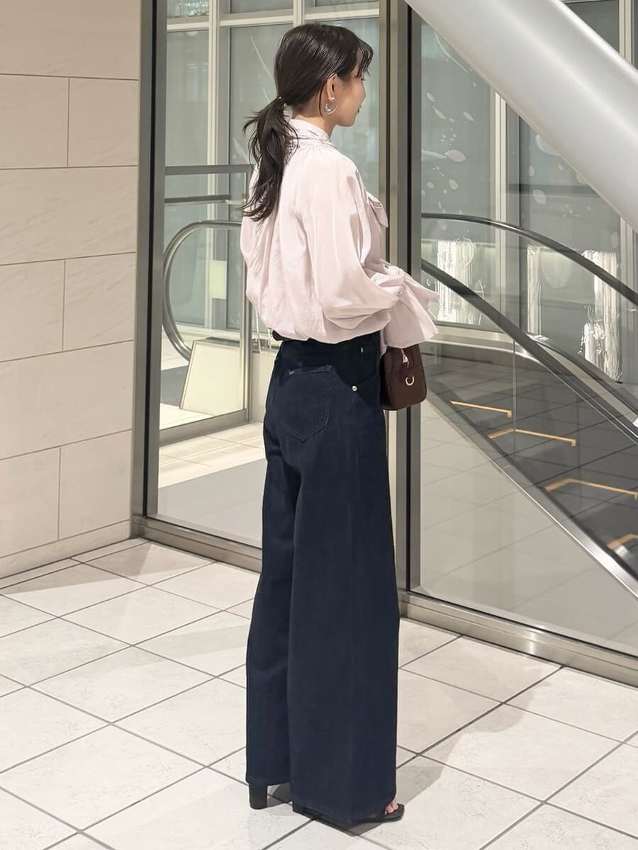 ブルー系のデニムパンツ、ブラウン系のハンドバッグ、ピンク系のシャツ/ブラウスを着用したレディースの冬コーディネートの8枚目の写真