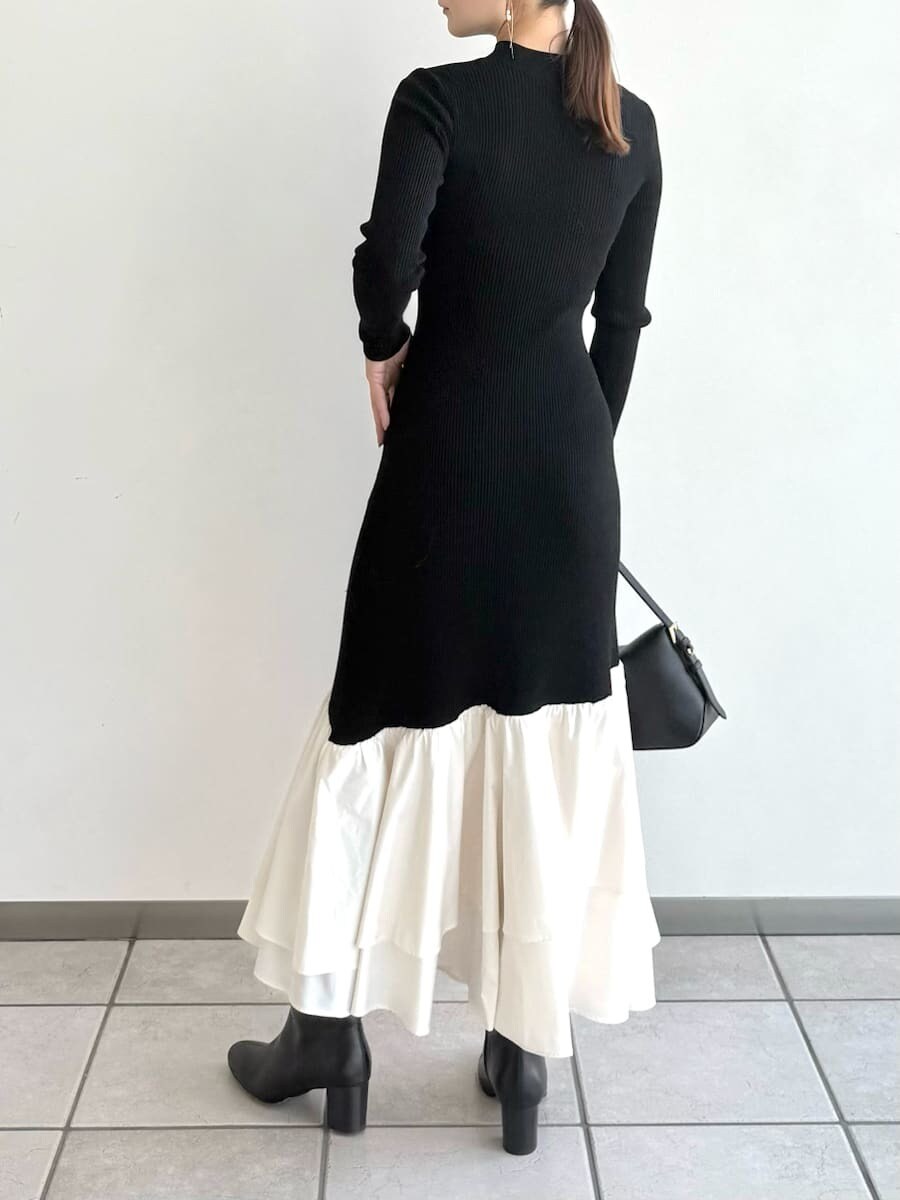 ブラック系のブーツ、その他のチェスターコート、ブラック系のハンドバッグを着用したレディースの秋コーディネートの6枚目の写真