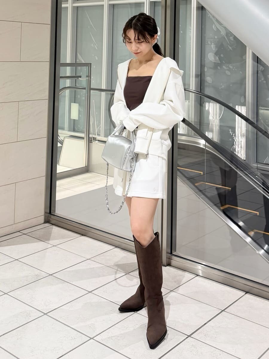 ブラウン系のブーツ、シルバー系のハンドバッグ、ホワイト系のパーカーを着用したレディースの冬コーディネートの9枚目の写真