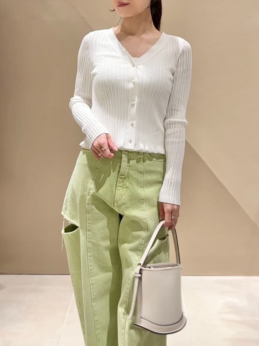 グリーン系のデニムパンツ、ホワイト系のニット/セーター、ホワイト系のハンドバッグを着用したレディースの冬コーディネートの6枚目の写真