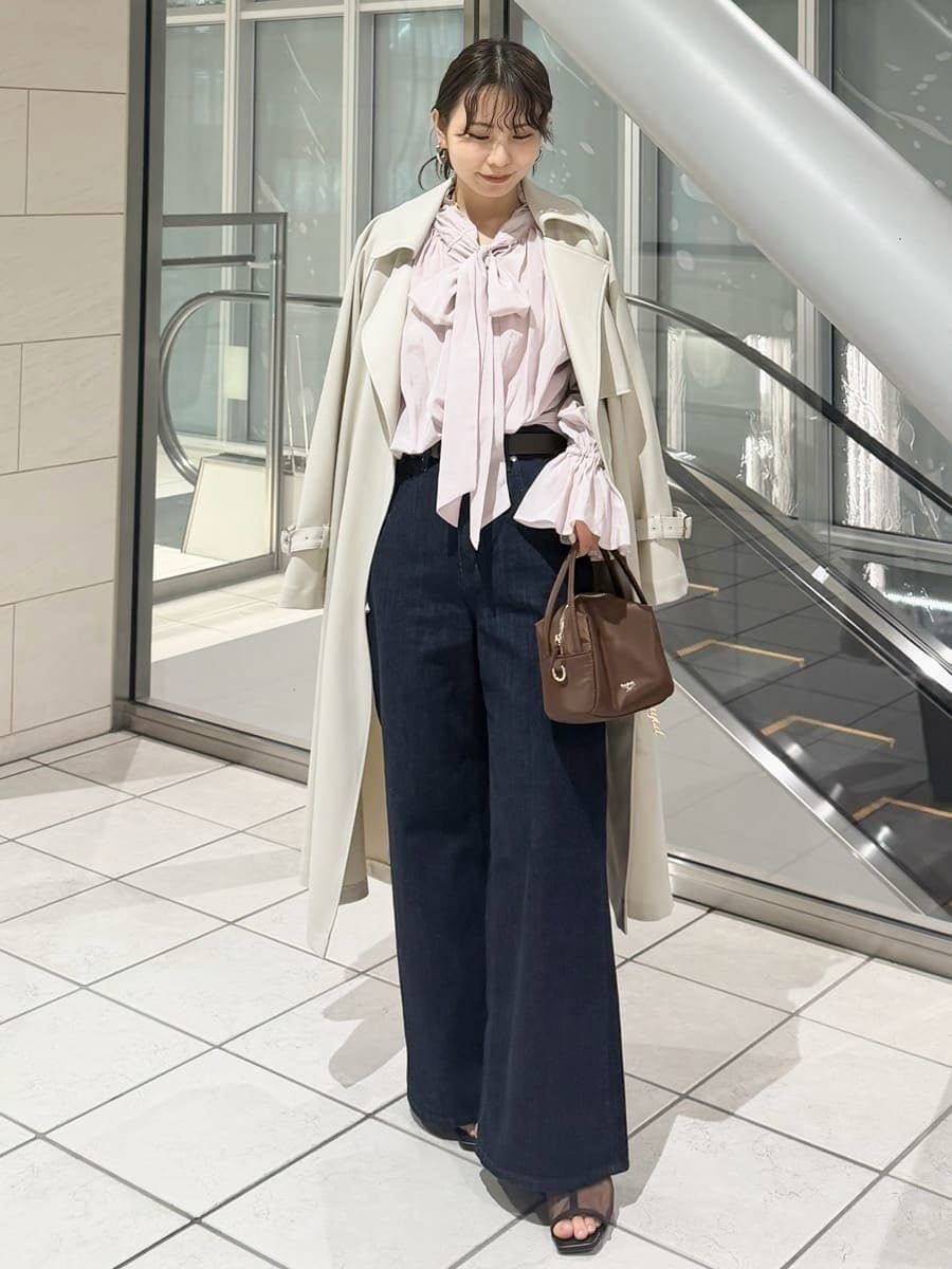 ブルー系のデニムパンツ、ブラウン系のハンドバッグ、ピンク系のシャツ/ブラウスを着用したレディースの冬コーディネートの3枚目の写真