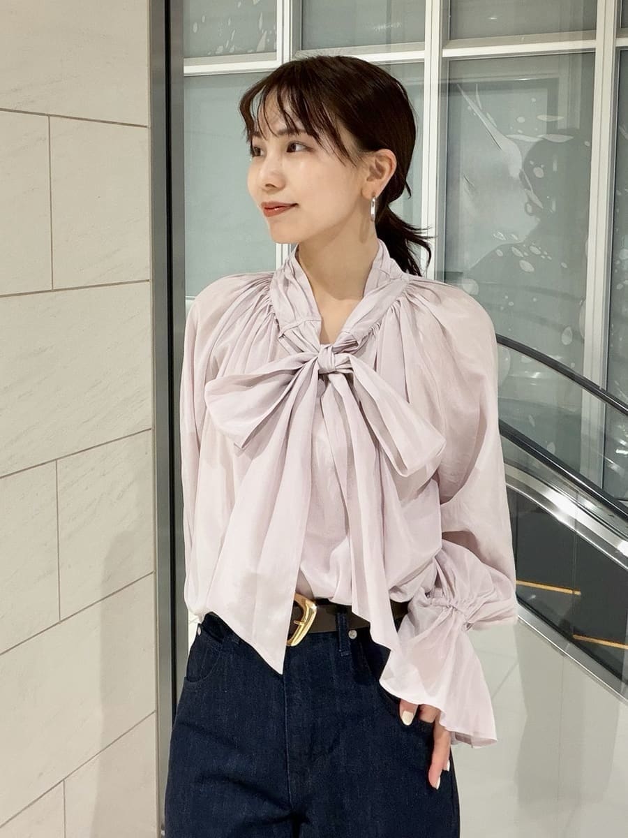 ブルー系のデニムパンツ、ブラウン系のハンドバッグ、ピンク系のシャツ/ブラウスを着用したレディースの冬コーディネートの10枚目の写真