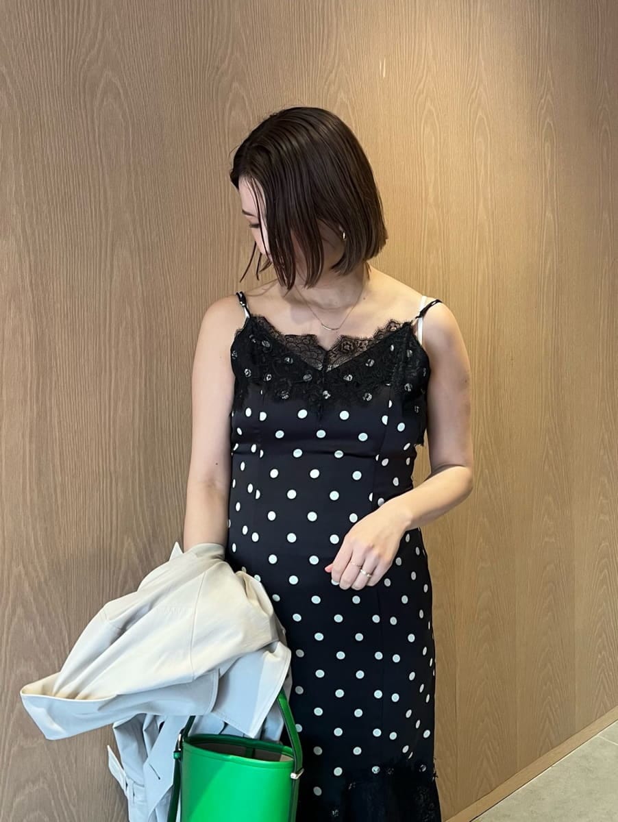 ベージュ系のトレンチコート、ブラック系のワンピース、グリーン系のハンドバッグを着用したレディースの春コーディネートの4枚目の写真