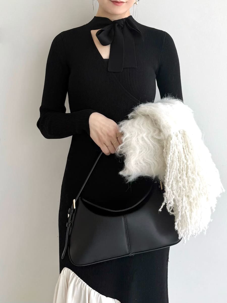 ブラック系のブーツ、その他のチェスターコート、ブラック系のハンドバッグを着用したレディースの秋コーディネートの10枚目の写真