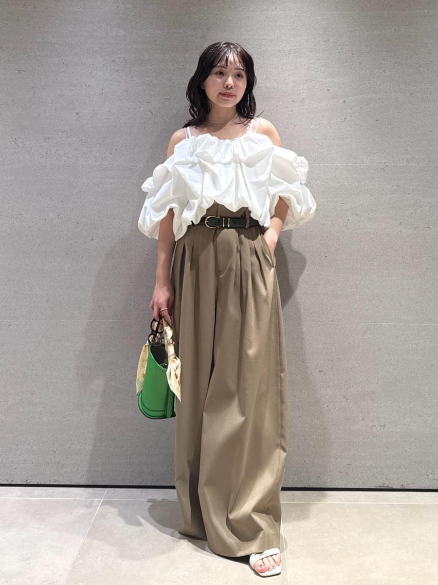 グリーン系のハンドバッグ、ホワイト系のサンダル、ホワイト系のシャツ/ブラウスを着用したレディースの冬コーディネートの5枚目の写真