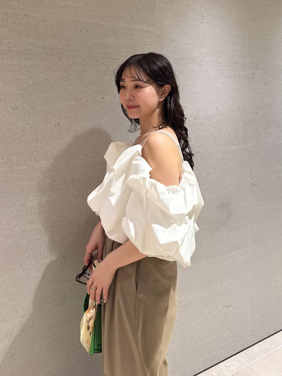 グリーン系のハンドバッグ、ホワイト系のサンダル、ホワイト系のシャツ/ブラウスを着用したレディースの冬コーディネートの10枚目の写真