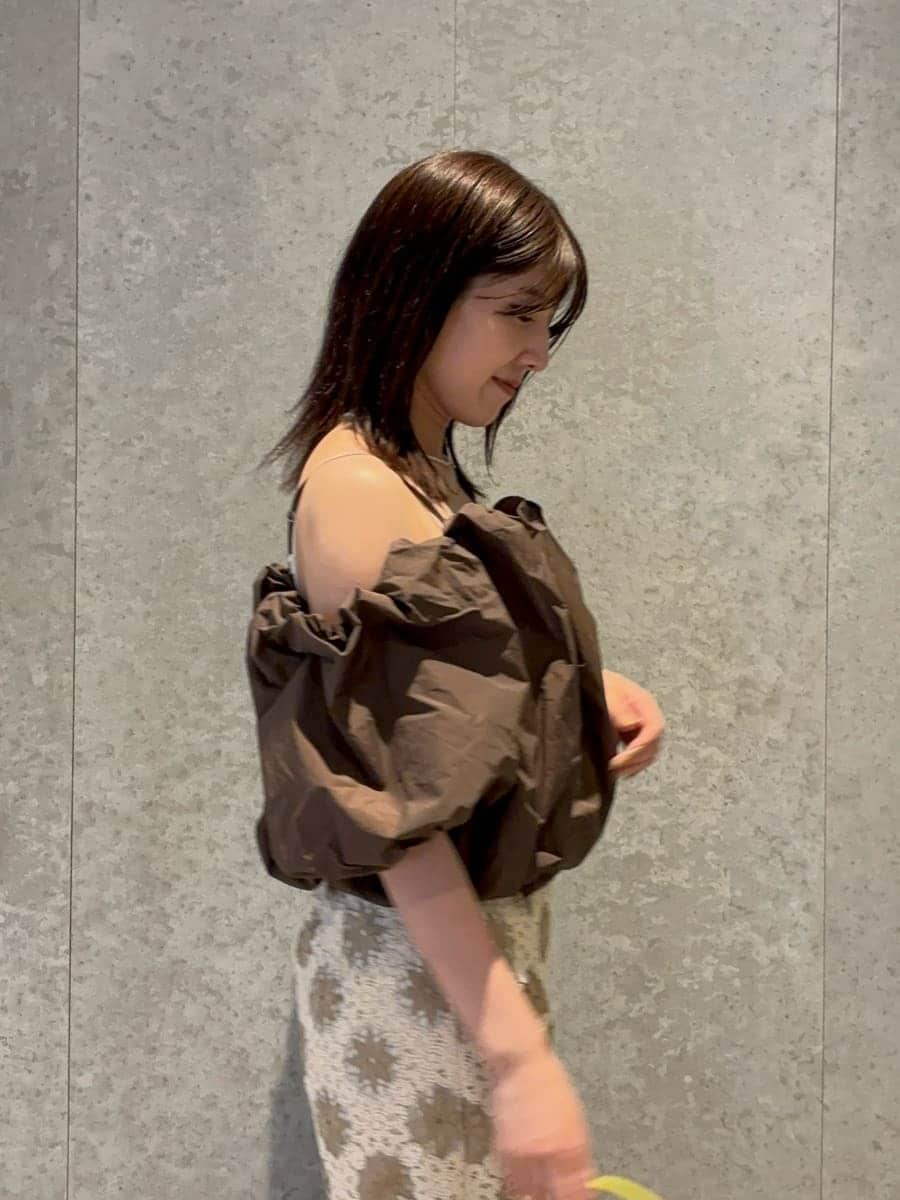 グリーン系のハンドバッグ、ブラウン系のシャツ/ブラウス、ブラウン系のサンダルを着用したレディースの春コーディネートの5枚目の写真