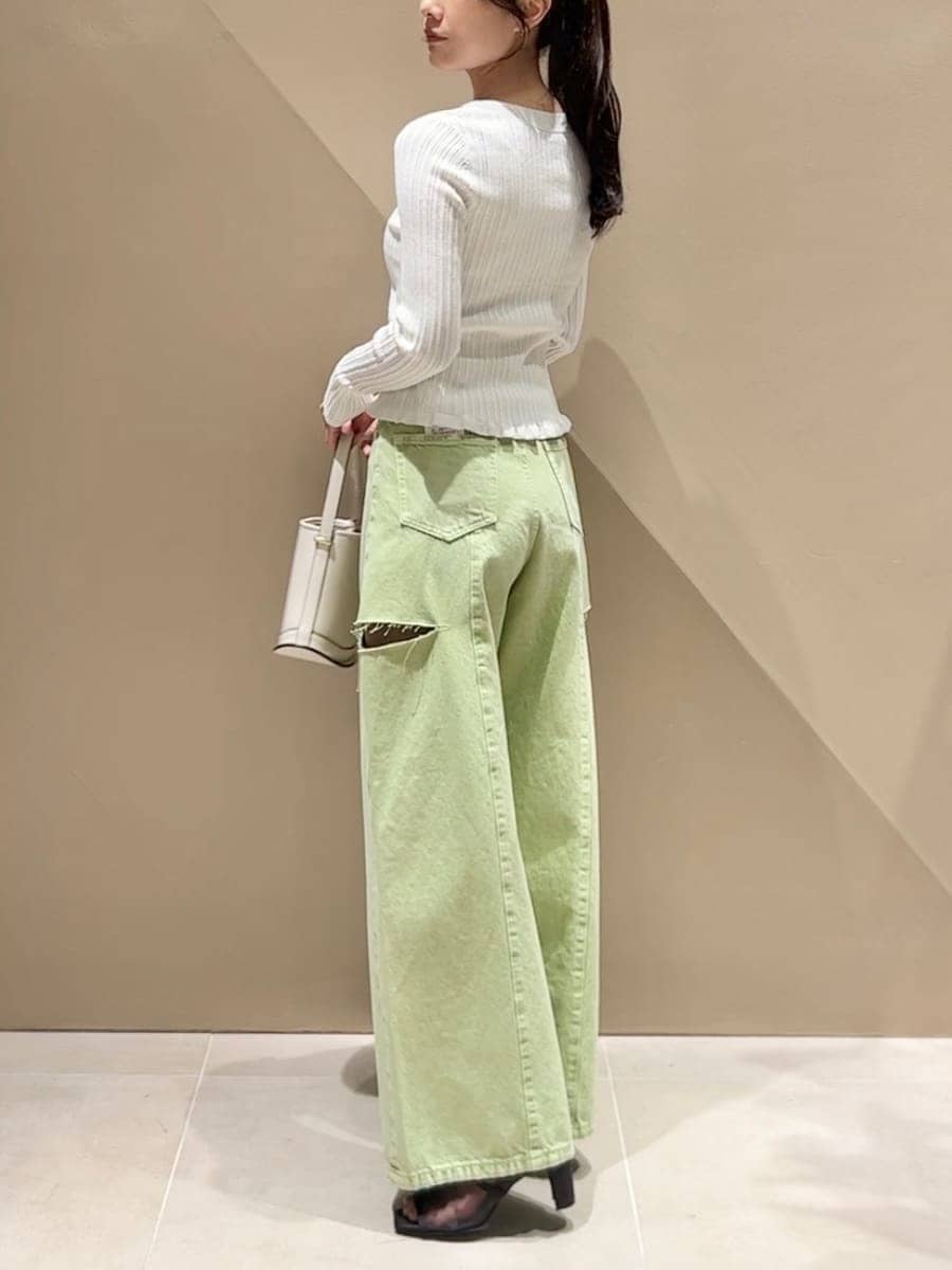 グリーン系のデニムパンツ、ホワイト系のニット/セーター、ホワイト系のハンドバッグを着用したレディースの冬コーディネートの4枚目の写真