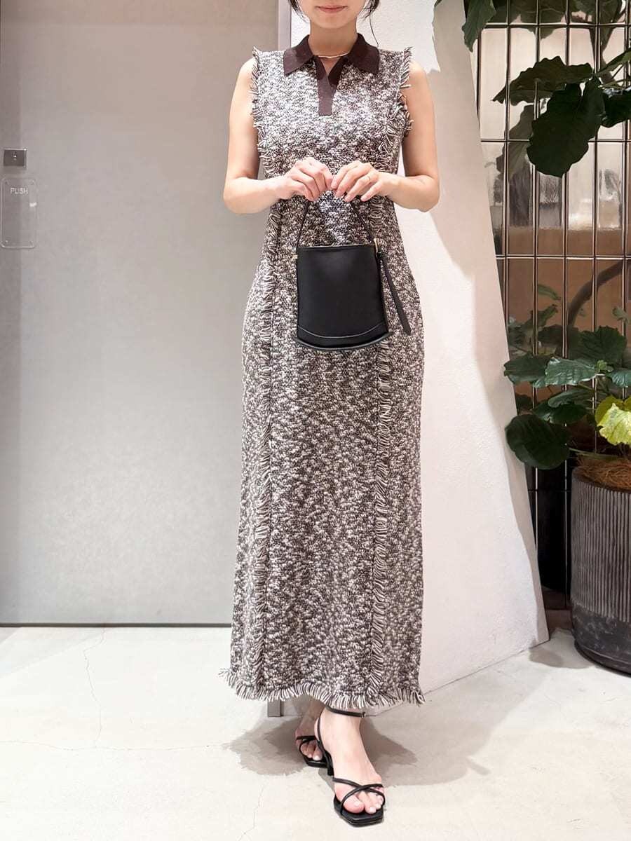 ブラック系のハンドバッグ、ブラック系のサンダル、シルバー系のネックレスを着用したレディースの夏コーディネートの4枚目の写真