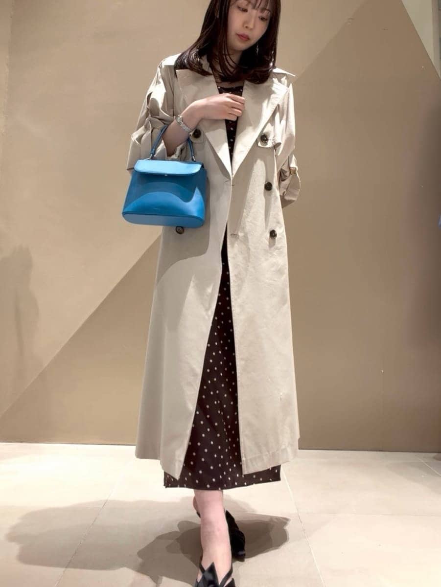 ブラック系のパンプス、ベージュ系のトレンチコート、ブラウン系のワンピースを着用したレディースの冬コーディネートの7枚目の写真