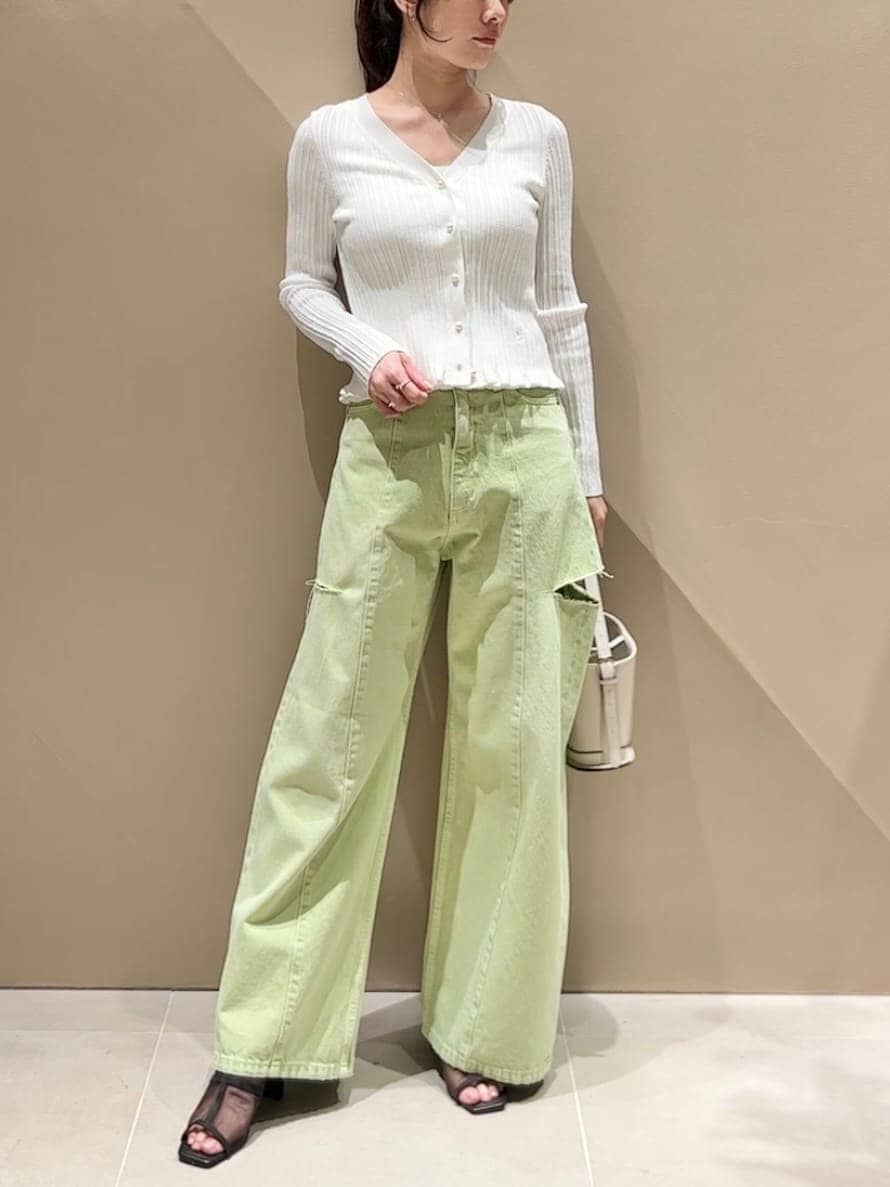 グリーン系のデニムパンツ、ホワイト系のニット/セーター、ホワイト系のハンドバッグを着用したレディースの冬コーディネートの3枚目の写真