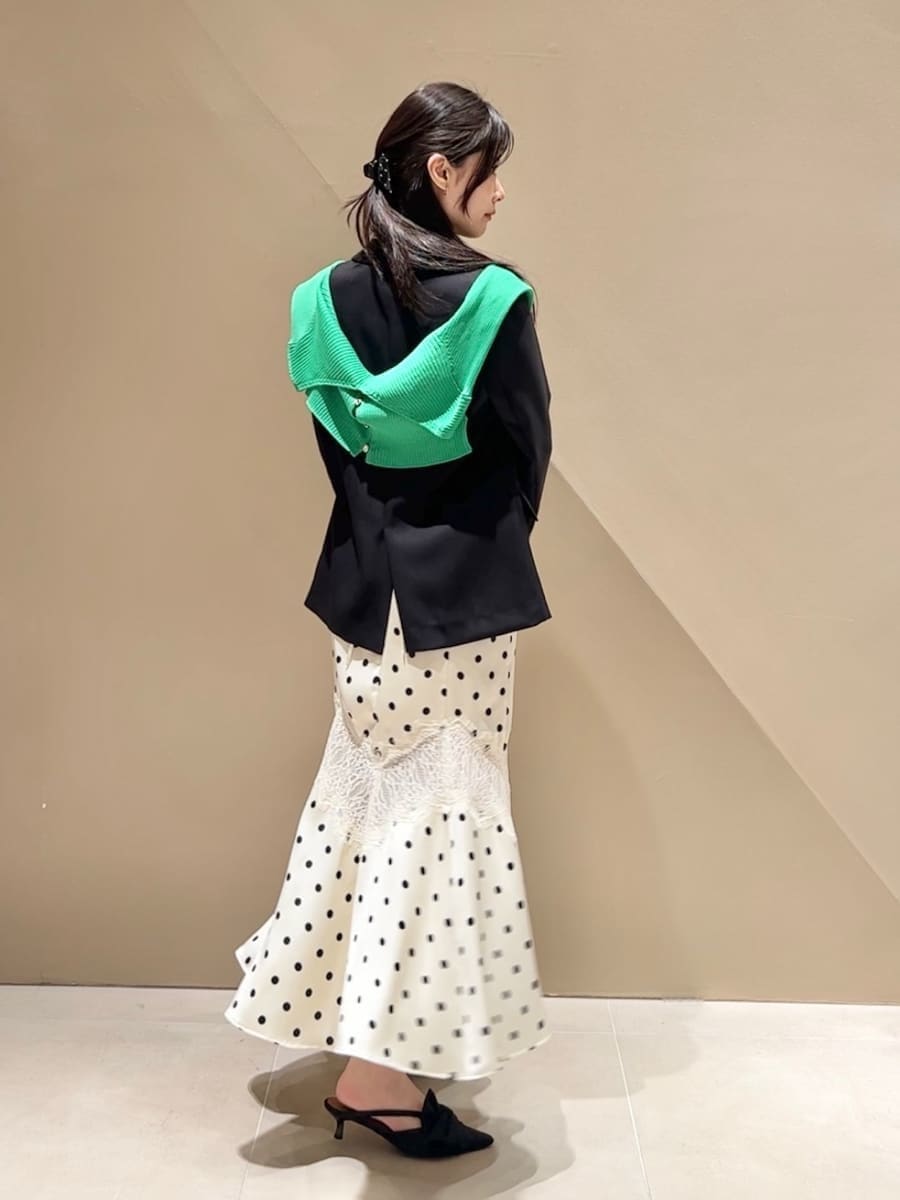 ブラック系のパンプス、ホワイト系のワンピース、グリーン系のカーディガン/ボレロを着用したレディースの春コーディネートの2枚目の写真