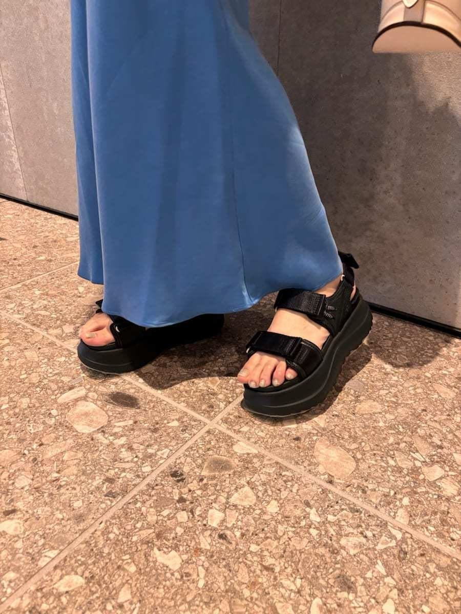 ホワイト系のハンドバッグ、ブラック系のサンダルを着用したレディースの春コーディネートの7枚目の写真