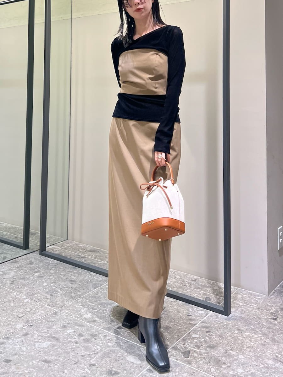 イエロー系のワンピース、ブラック系のTシャツ/カットソー、イエロー系のショルダーバッグを着用したレディースの秋コーディネートの2枚目の写真