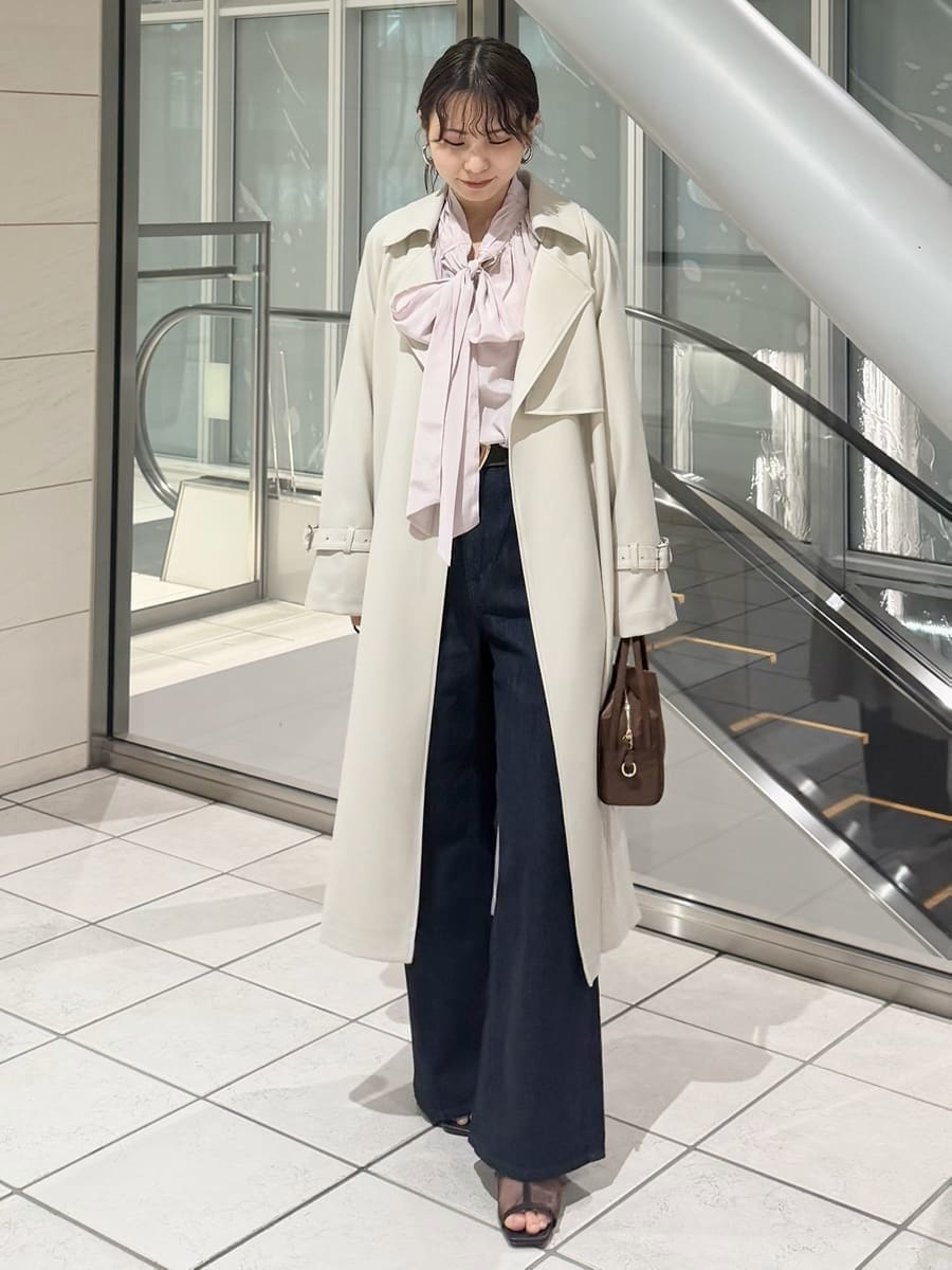 ブルー系のデニムパンツ、ブラウン系のハンドバッグ、ピンク系のシャツ/ブラウスを着用したレディースの冬コーディネートの4枚目の写真