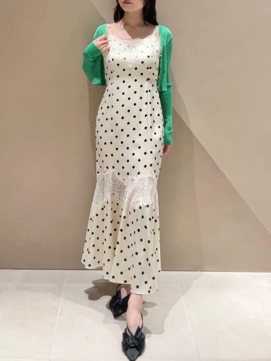 ブラック系のパンプス、ホワイト系のワンピース、グリーン系のカーディガン/ボレロを着用したレディースの春コーディネートの5枚目の写真