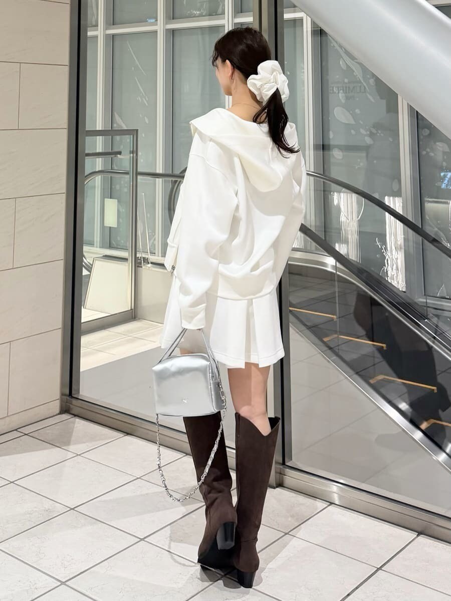 ブラウン系のブーツ、シルバー系のハンドバッグ、ホワイト系のパーカーを着用したレディースの冬コーディネートの6枚目の写真