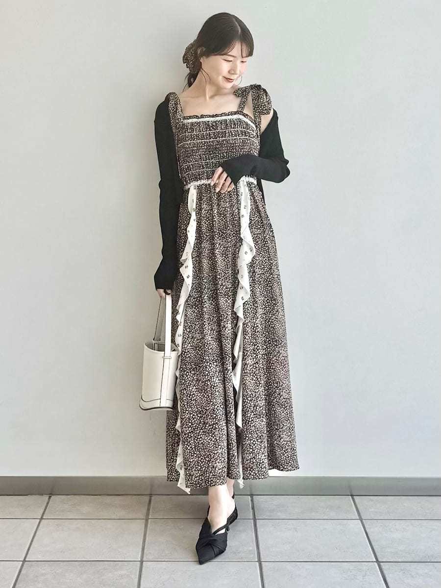 ブラック系のパンプス、ブラック系のカーディガン/ボレロ、ホワイト系のハンドバッグを着用したレディースの春コーディネートの2枚目の写真