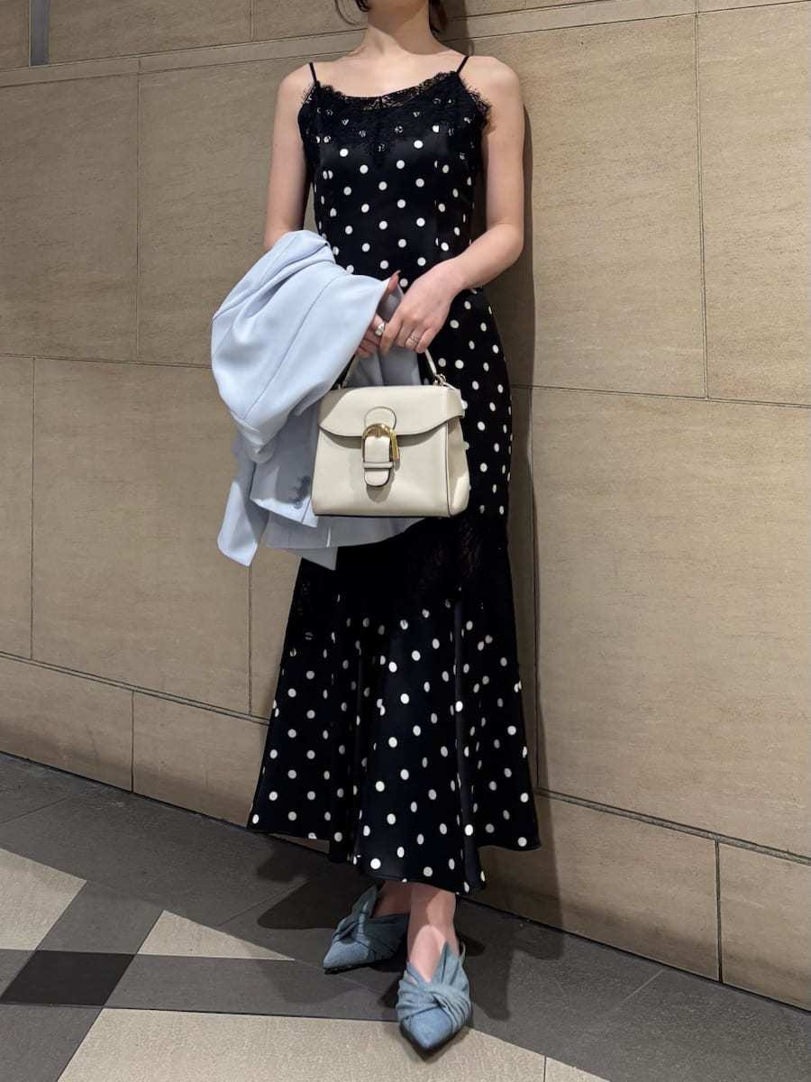 ブルー系のパンプス、ブラック系のワンピース、ベージュ系のハンドバッグを着用したレディースの春コーディネートの3枚目の写真