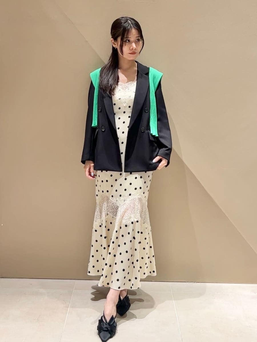 ブラック系のパンプス、ホワイト系のワンピース、グリーン系のカーディガン/ボレロを着用したレディースの春コーディネートの3枚目の写真