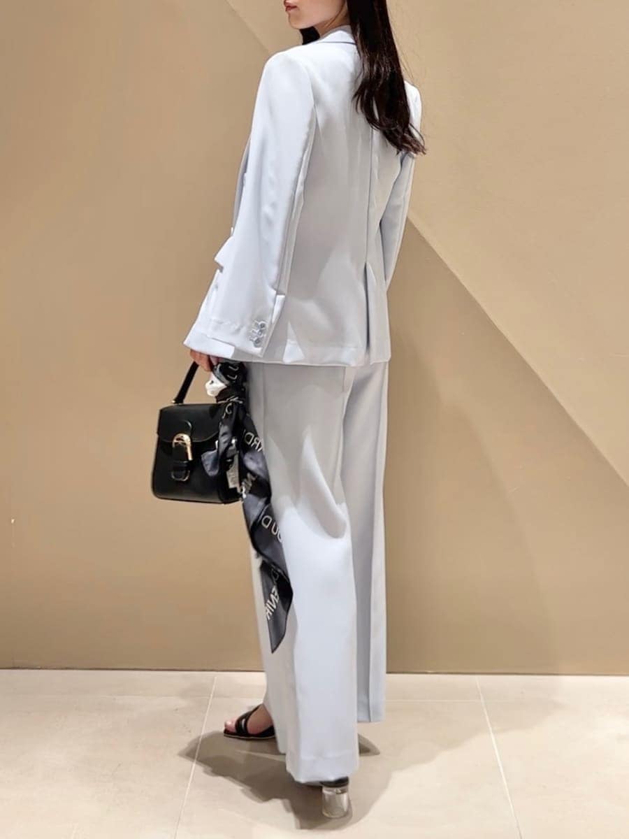 ブラック系のハンドバッグ、ブラック系のサンダル、ブルー系のテーラードジャケットを着用したレディースの春コーディネートの2枚目の写真