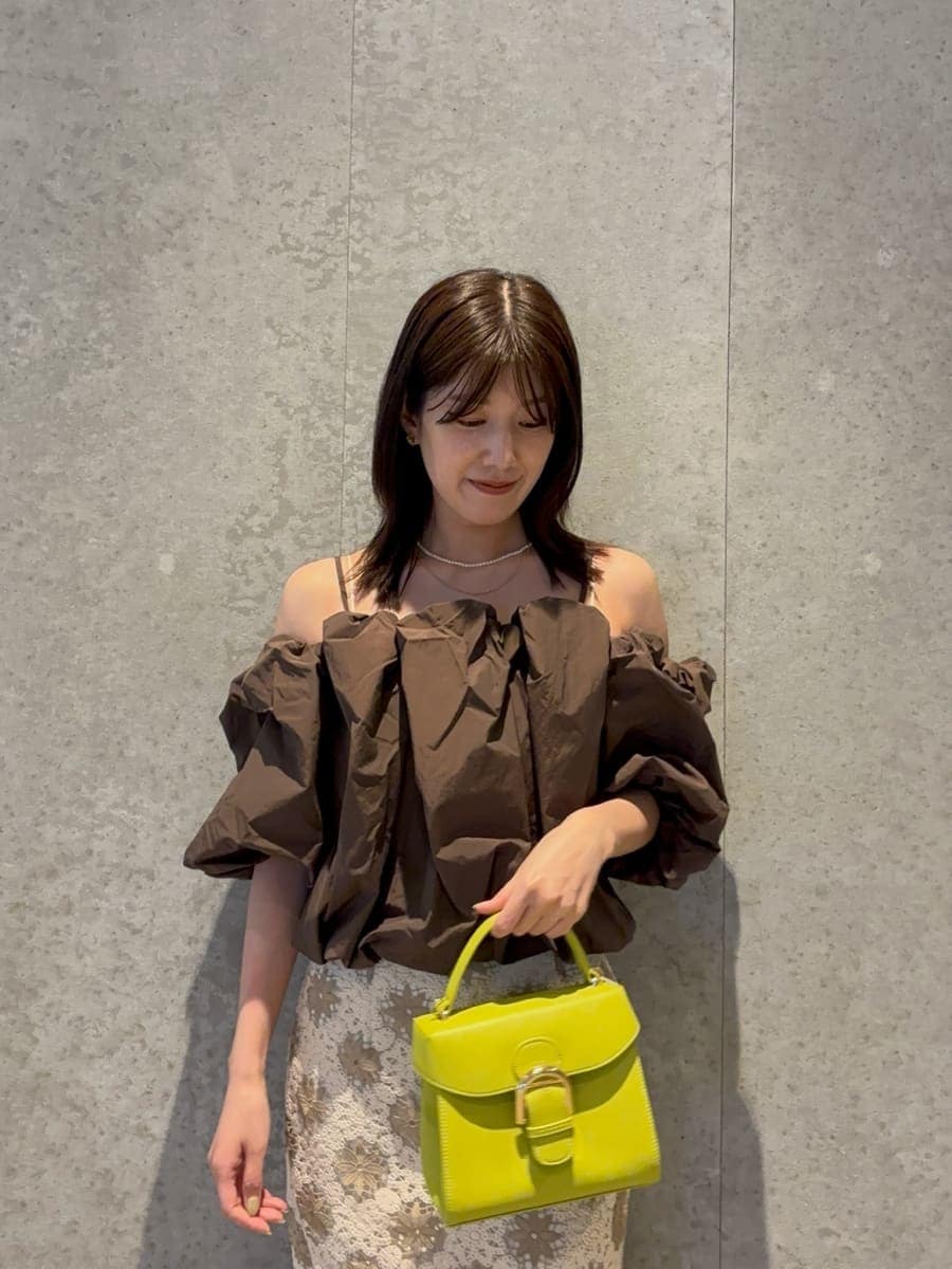 グリーン系のハンドバッグ、ブラウン系のシャツ/ブラウス、ブラウン系のサンダルを着用したレディースの春コーディネートの4枚目の写真